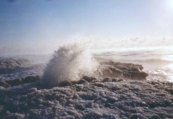 Wave crashing against ice bank